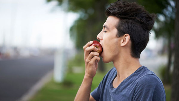 Человек ест яблоки